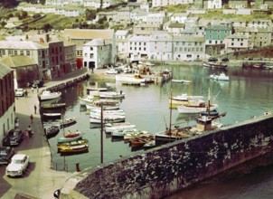 Boats at moorings in the harbour at seaside fishing village of Mevagissey, Cornwall, England, UK c