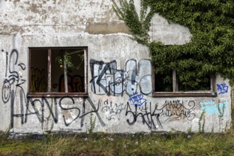Grafity on an old house wall, dilapidated plant of a former agricultural production cooperative of