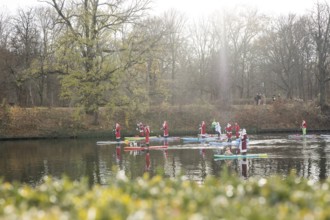 Water sports enthusiasts dressed up as Santa Claus ride SUPs on the Spree am Park at the