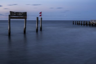 Wooden sign in the sea with inscription Zingst and Buhnen, long exposure, evening light, Zingst,