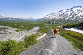 Hikers on glacial moraine, view of the vast Tsina River valley with mountains, Worthington Glacier