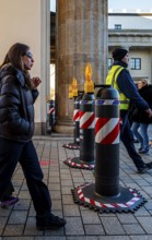 Passers-by at the security barrier made of massive bollards at the Brandenburg Gate passage,