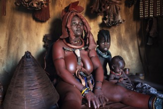 Himba woman sitting with baby, Himba perfume, scented smoke from burning plants, Himba village,