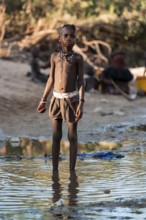 Himba child washing with water on a river, traditional Himba, Kaokoveld, Kunene, Namibia