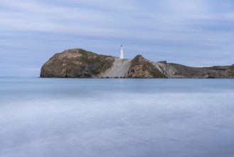 Castlepoint Beach with lighthouse on the rock, ocean, long exposure. Castlepoint, Wairarapa Coast,