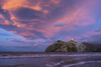 Castlepoint Beach, ocean and lighthouse on a rock, evening, sunset, dramatic sky. Castlepoint,