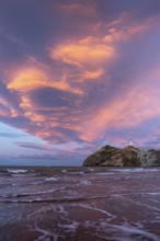 Castlepoint Beach, ocean and lighthouse on a rock, evening, sunset, dramatic sky. Castlepoint,