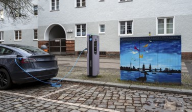 Electric charging station next to a blue-painted distribution box on public roads, Berlin, Germany