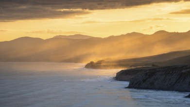 Wairarapa coast at sunset. Sea, mountains, backlight. Castlepoint, Wairarapa Coast, Wellington