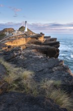 Castlepoint lighthouse on a rock, sea, sunrise. Castlepoint, Wairarapa Coast, Wellington Region,
