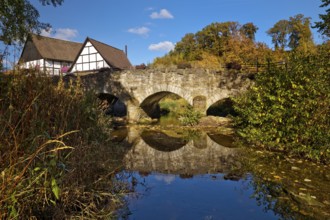 The river Hönne with the old Hönnetalbrücke in autumn with half-timbered house in Volkringhausen,