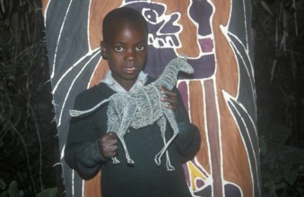 Child with homemade artwork in a self-help project in Chitungwiza near Harare, Zimbabwe, Africa,