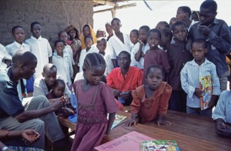 In a World Vision project, friends and neighbors have gathered on the occasion of a godfather's