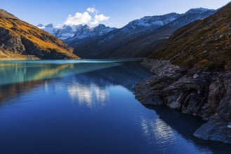 The turquoise Lac de Moiry reservoir, behind the peaks of the Grand Cornier, Tete Blanche and