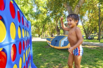 Happy child celebrating winning a game of giant four in a row in a park in kamloops, british
