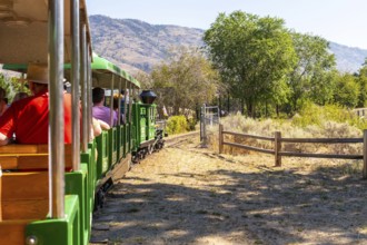 Tourists enjoying a delightful ride on a miniature train, taking in the stunning landscapes of