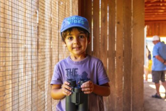 Curious child holding binoculars, exploring the wonders of nature at the british columbia wildlife