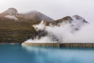Fog rises over the dam of the Lac de Moiry Reservoir, Val d'Anniviers, Valais Alps, Canton of
