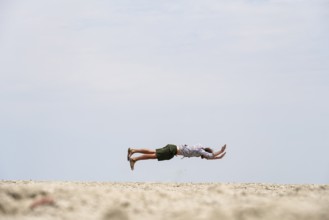 Abstract, man jumping horizontally at the Etosha pan, salt pan, Etosha National Park, Namibia