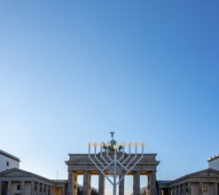 Large Hanukkah chandelier at the Brandenburg Gate in daylight, sign of lively Jewish life, symbolic