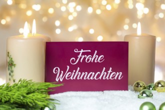 Greeting card with the inscription FROHE WEIHNAHCHTEN between Christmas accessories with bokeh in