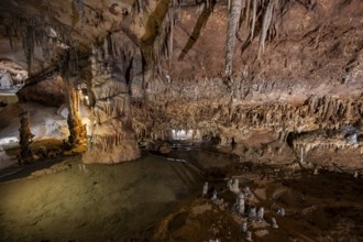 Stalactites and stalagmites, rock formations in a stalactite cave with water basin, Grotta del