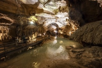 Stalactites and stalagmites, small underground lake, rock formations in a stalactite cave, Grotta