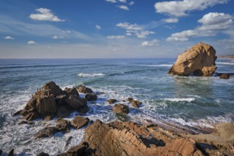 Penedo do Guincho, a large boulder rock arch at Praia da Santa Cruz, Portugal, with ocean waves and