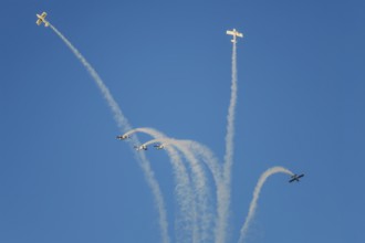 Stunt aerobatic planes performing stunts in blue sky with smoke trail. Concept of teamwork,