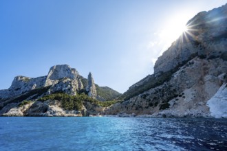 Light blue clear sea on a dream beach on Cala Goloritzé, picturesque rocky coast with sun stars,