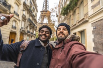 Two men smiling for a selfie on a paris street, posing with the eiffel tower in the background as