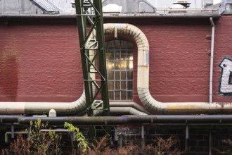 District heating pipeline in front of old industrial buildings on the banks of the Wupper,