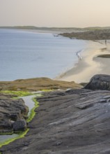 Granite rocks in the evening light and turquoise blue sea at Gurteen Beach, Roundstone, County