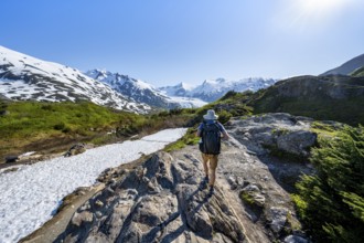 Hikers on the Portage Pass Trail, snow-covered mountains and Portage Glacier glaciers, near