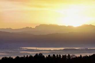 View from Horben of Lake Zug with the city of Cham and Zug covered in fog, behind it the