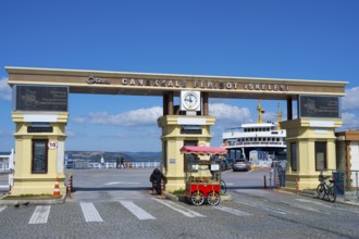 The entrance to the ferry terminal with clock and a kiosk in sunny weather, Çanakkale, Canakkale,