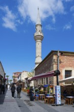 Street view with minaret and cafes under a clear blue sky, Yali Mosque, Tavil Ahmet Aga Mosque,