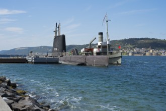 A submarine and a ship in the harbor with a view of the city beyond, TCG Uluçalireis S-338, War
