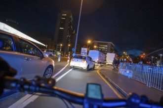 Cycling in the city, in the dark, in the evening, cycling on a bike lane, marked, between 2 lanes,