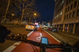Cycling in the city, in the dark, in the evening, cycling on a bike lane, marked, Huyssenallee,