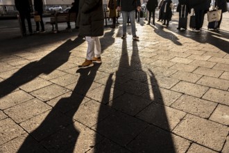Passers-by on a sidewalk on Grunerstraße, near Alexander Platz, bus stop, in Berlin, shade, low