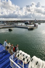 Tourists on the ferry to Rügen, ferry terminal, harbor with cityscape, St. Nicholas Church,