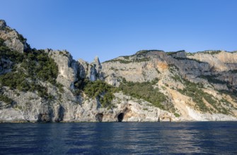 Picturesque rocky coast, cliffs in morning light, blue sea, Golfo di Orosei, Baunei, Sardinia,