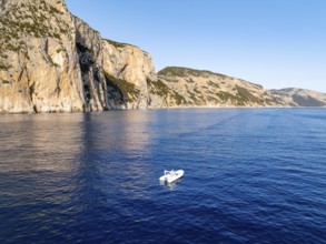 Motorboat off picturesque rocky coast ImmorgenLicht, cliffs, Golfo di Orosei, Baunei, Sardinia,