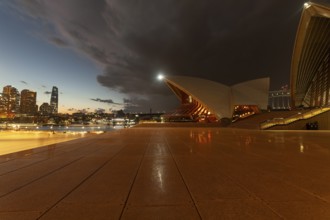 Cloudy sky over skyscrapers and promenade, Sydney CBD at dusk. At the Sydney Opera House, Australia