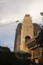 Side view of Sydney Harbour Bridge at sunset with the Australian flag