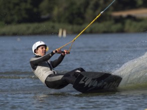 Young man with wakeboard, sporty on water, athletic model, active water sports, wake park