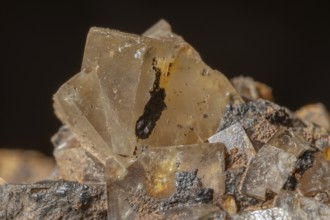 Bright, square crystals are visible on a piece of rock. The light underlines their structure and