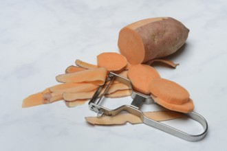 Sweet potatoes with potato peeler, potato slices, partially peeled, Ipomoea batatas