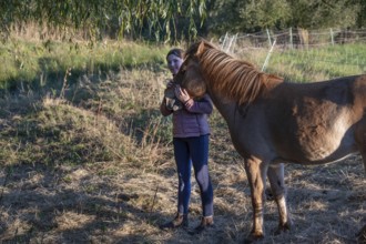 Young girl with her horse in the pasture, Othenstorf, Mecklenburg-Vorpommern, Germany